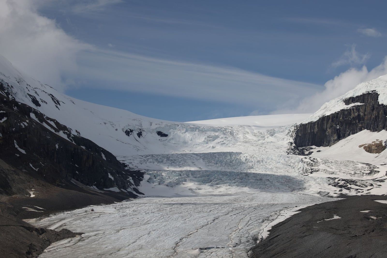 Snow and ice cover the Athabasca Glacier as it flows between mountain slopes toward the Columbia Icefield.